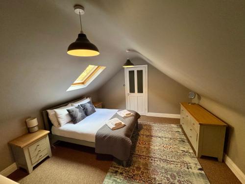 a small bedroom with a bed and a staircase at Sunset Cottage in Hunstanton