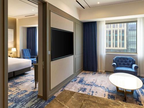 a hotel room with a bed and a flat screen tv at Grand Mercure Imperial Palace Seoul Gangnam in Seoul