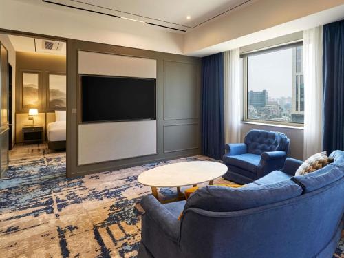 a hotel room with two chairs and a television at Grand Mercure Imperial Palace Seoul Gangnam in Seoul
