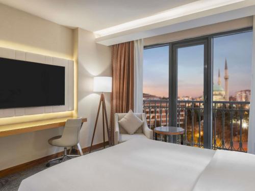 a hotel room with a bed and a large window at Mercure Ankara Kızılay in Ankara