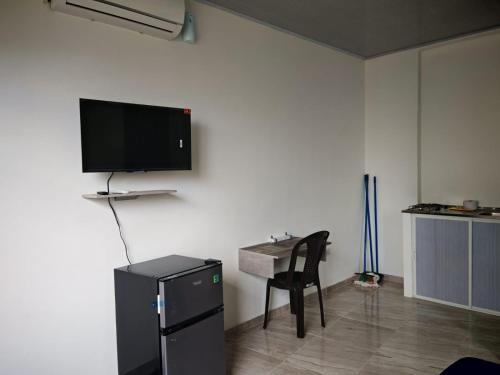 a room with a desk and a tv on a wall at hotel Air b&b altos del peñon in Girardot