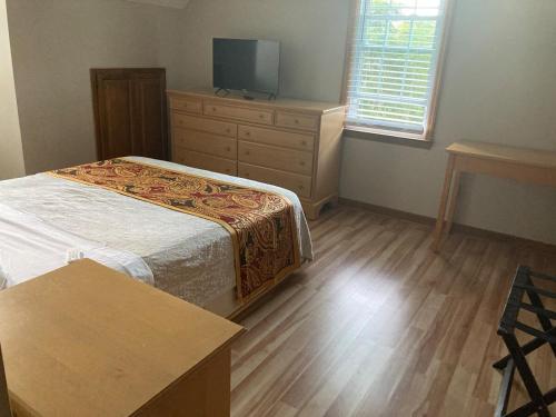 a bedroom with a bed and a dresser and a tv at Knight play Golf court house in Apex
