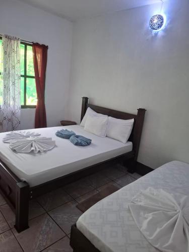 a bedroom with a bed with two towels on it at Cabinas Tortuguero Natural in Tortuguero