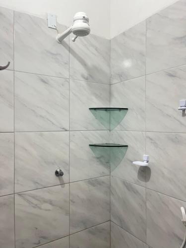 a bathroom with a shower with a glass door at Chalé da Kikia in Icapuí