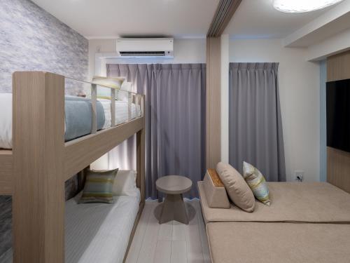 a bedroom with two bunk beds and a couch at The Riverfront Residence Nishihiroshima in Hiroshima
