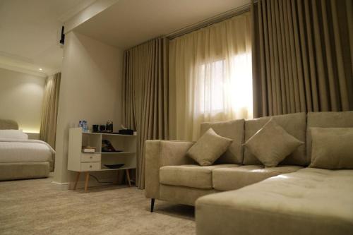 una sala de estar con un sofá y una cama en نسيم الحرم, en Ash Shishah