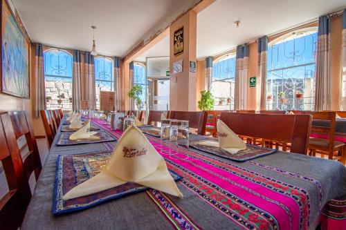 a dining room with tables and chairs and windows at Los Portales de Chivay in Chivay