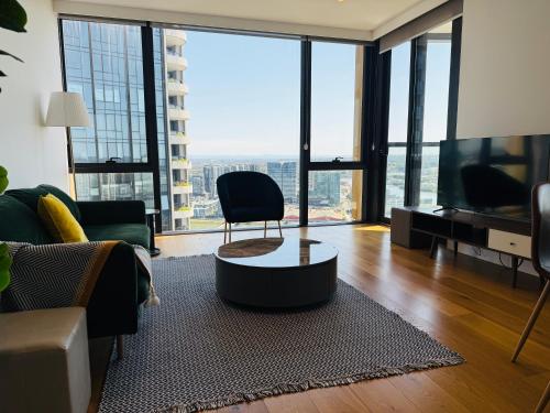 a living room with a couch and a chair and a television at Brand New Waterview family residence 3 bedrooms -Pool, Parking in Sydney