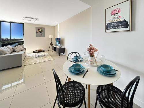 a dining room and living room with a table and chairs at The River at Parramatta wif Free parking in Sydney
