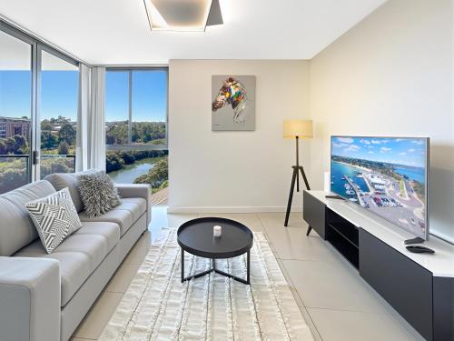 a living room with a couch and a flat screen tv at The River at Parramatta wif Free parking in Sydney