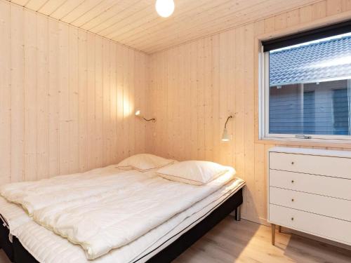 una piccola stanza con un letto e una finestra di 5 star holiday home in Jerup a Bratten Strand