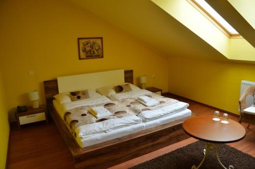 a bedroom with a large bed in a yellow room at Penzion Bokros in Patince