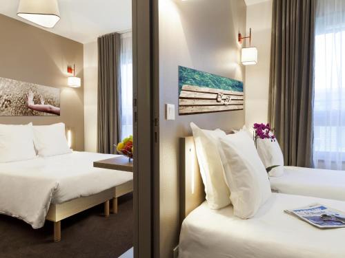 una camera d'albergo con due letti e una finestra di Apartment Near Geneva with Parking ad Annemasse