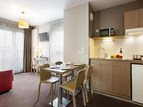una cucina e una sala da pranzo con tavolo e sedie di Apartment Near Geneva with Parking ad Annemasse