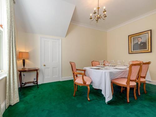 a dining room with a table with chairs and a chandelier at Langford Villa in Filey