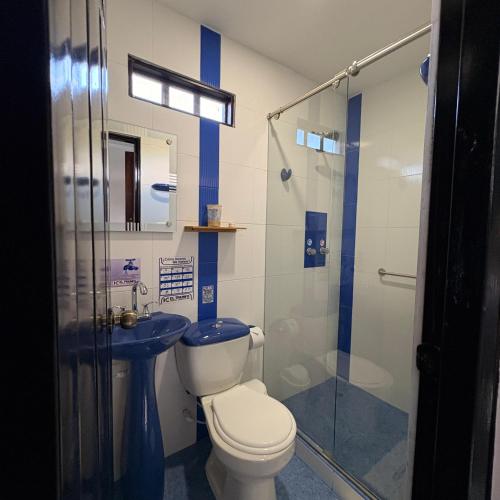 a bathroom with a toilet and a glass shower at Hotel Campestre El Triunfo in San Agustín