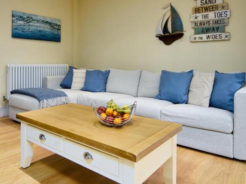 a living room with a bowl of fruit on a coffee table at Black Rock Hideaway in Porthmadog