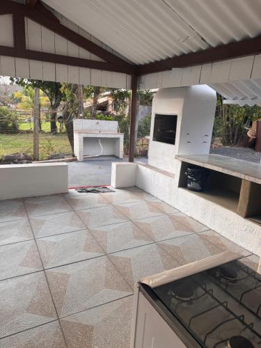 an outdoor patio with a stove and a grill at Cute Rustic Cottage by the River in Caximba
