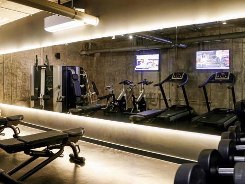 a gym with several treadmills and exercise bikes at Aparthotel Adagio London Brentford in Brentford