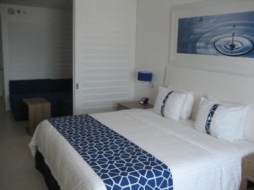 a bedroom with a large bed with a blue and white comforter at Holiday Inn Acapulco La Isla by IHG in Acapulco