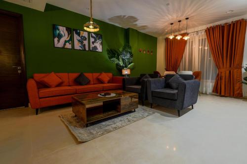 a living room with a couch and two chairs and a table at Penta Square Signature Apartments DHA Phase 5 Lahore in Lahore