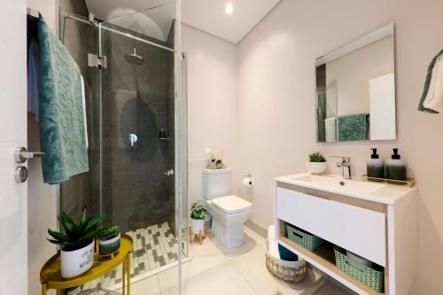 a bathroom with a shower and a toilet and a sink at Sandtongate Heights in Johannesburg