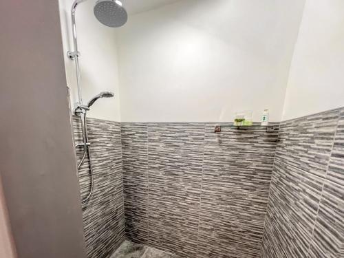 a shower in a bathroom with a tiled wall at Emmotland Retreat - Uk44180 in Brandesburton