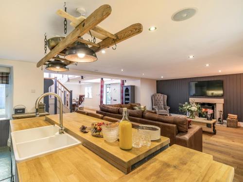 a kitchen and living room with a wooden ceiling at South Carolina Farm House in Tansley