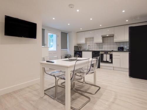 a kitchen with a white table and chairs at The Suffolk-Uk41441 in Brandon