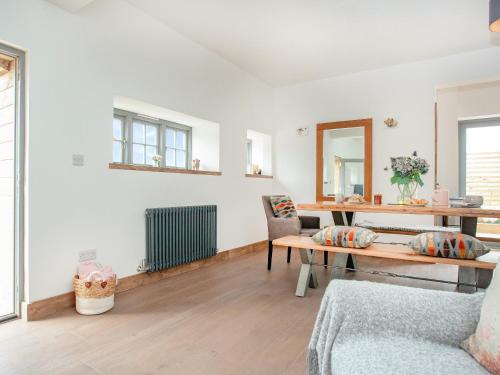 a living room with a table and a chair at Old Highwood - Hog End in Luppitt