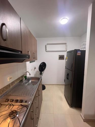 a small kitchen with a sink and a refrigerator at Silvia Maria Lodging House in Valledupar