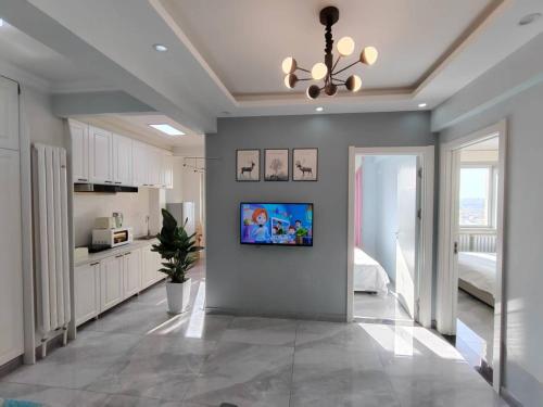 a living room with a television on a wall at Central Avenue Apartment in Harbin