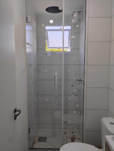 a bathroom with a glass shower with a toilet at Apartamento Solar dos Pampas in Guaíba