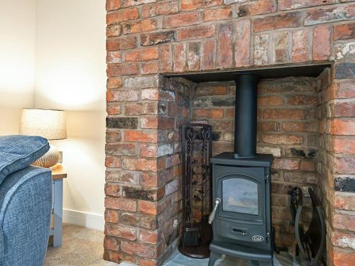 a brick fireplace with a stove in it at Salem Porter- Uk34814 in Tattershall