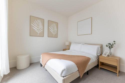 a bedroom with a bed and two pictures on the wall at The Lightwell - Sunlit Beachside Escape with Rooftop in Melbourne