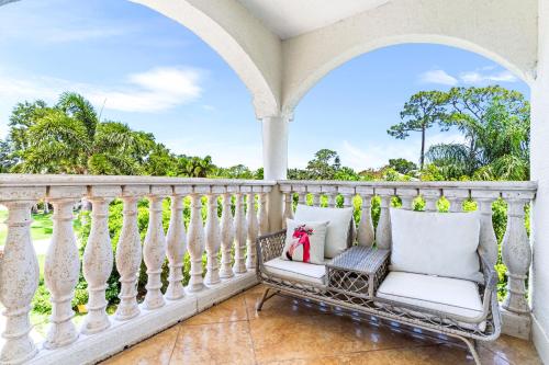 a porch with a white railing and a chair at Paradise in Time in Port Saint Lucie
