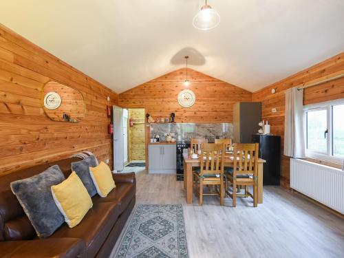 a living room with a couch and a table at Llwynog Lodge in Montgomery