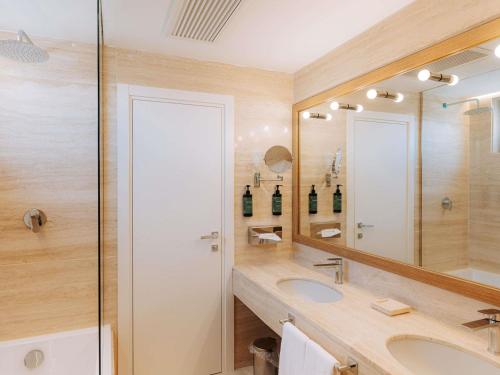 a bathroom with a sink and a mirror at Mövenpick Hotel Bari in Bari