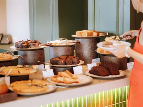 a buffet with different types of pastries on plates at Mövenpick Hotel Bari in Bari