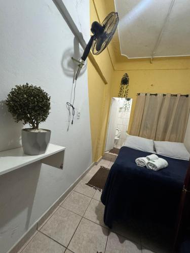 a small room with a bed and a potted plant at Pousada Mãe Linda in Aparecida