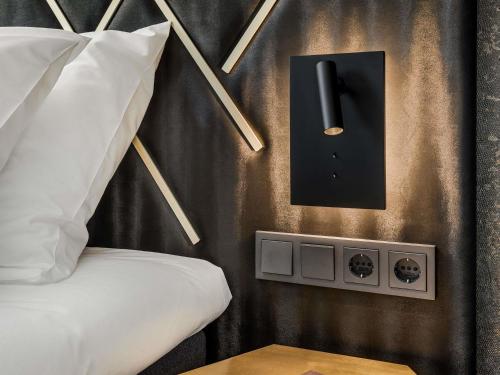 a bedroom with a bed and a black wall with a lightswitch at Le Marin Hotel Rotterdam City - Handwritten Collection in Rotterdam