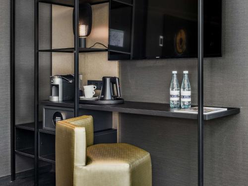 a room with a chair and a counter with drinks at Le Marin Hotel Rotterdam City - Handwritten Collection in Rotterdam