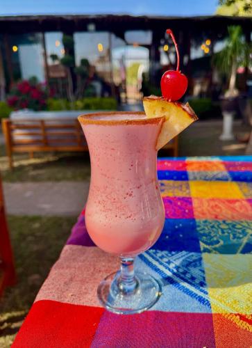 a drink with a cherry on top of a colorful table at Vicalis Hotel, Villas y Glamping in San Sebastian Xolalpa