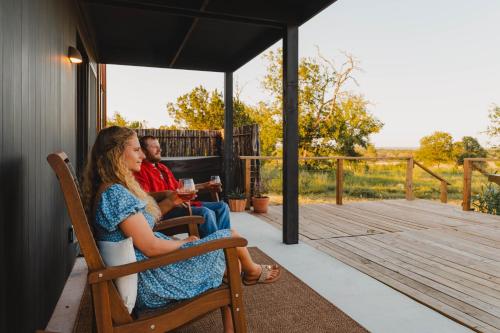 a man and woman sitting on a bench on a porch at The Martinsburg in Stonewall