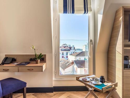 a room with a table and a window with a view at MADISON Saint Jean de Luz - Handwritten Collection in Saint-Jean-de-Luz