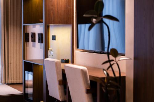 a dining room with a table and white chairs at YiQuan RIVERVIEW B&B in Fenghuang