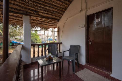 a room with a table and two chairs and a door at Forget Me Not Resort in Agonda