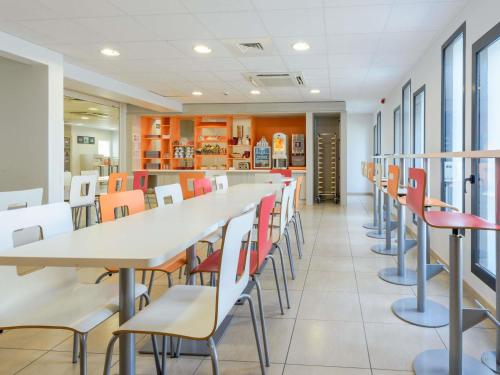 a row of tables and chairs in a cafeteria at Hôtel Eco La Rochelle Centre les Minimes in La Rochelle