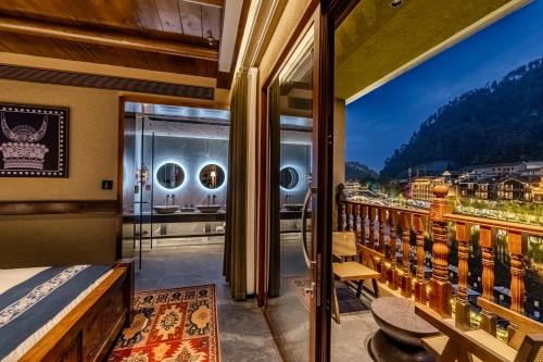 a room with a balcony with a bed and a view at YiQuan RIVERVIEW B&B in Fenghuang