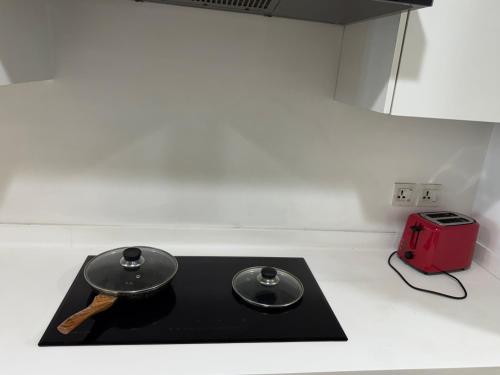 a black counter top with a red toaster next to it at Gold Crest Executive Hotel Apartments City View DHA Lahore in Lahore